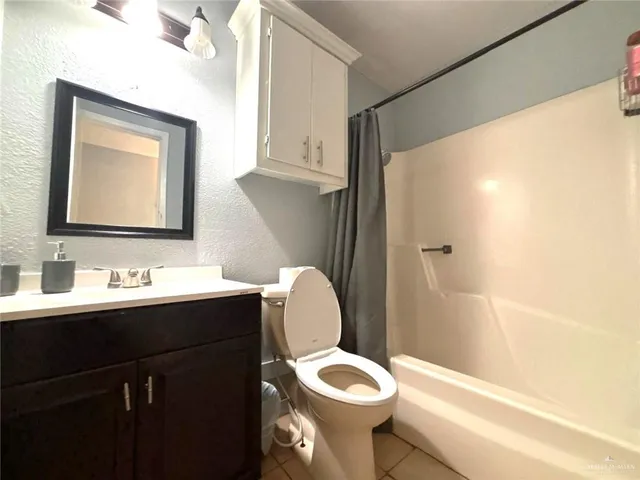 a bathroom with a toilet sink vanity and mirror