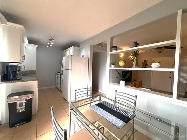a kitchen with a refrigerator and a stove top oven
