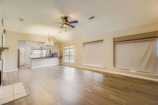 a view of empty room with wooden floor and fireplace
