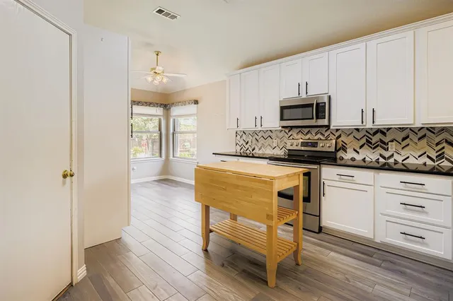 a kitchen with stainless steel appliances a refrigerator and a stove top oven