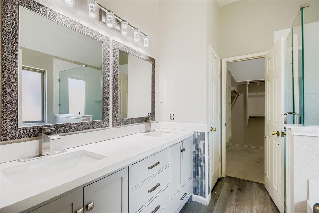 5452 Buckskin Drive The Colony, TX 75056 - Photo 22 of 31 Full bath featuring luxary Vinyl Plank, a spacious closet, double vanity, and updated stall shower