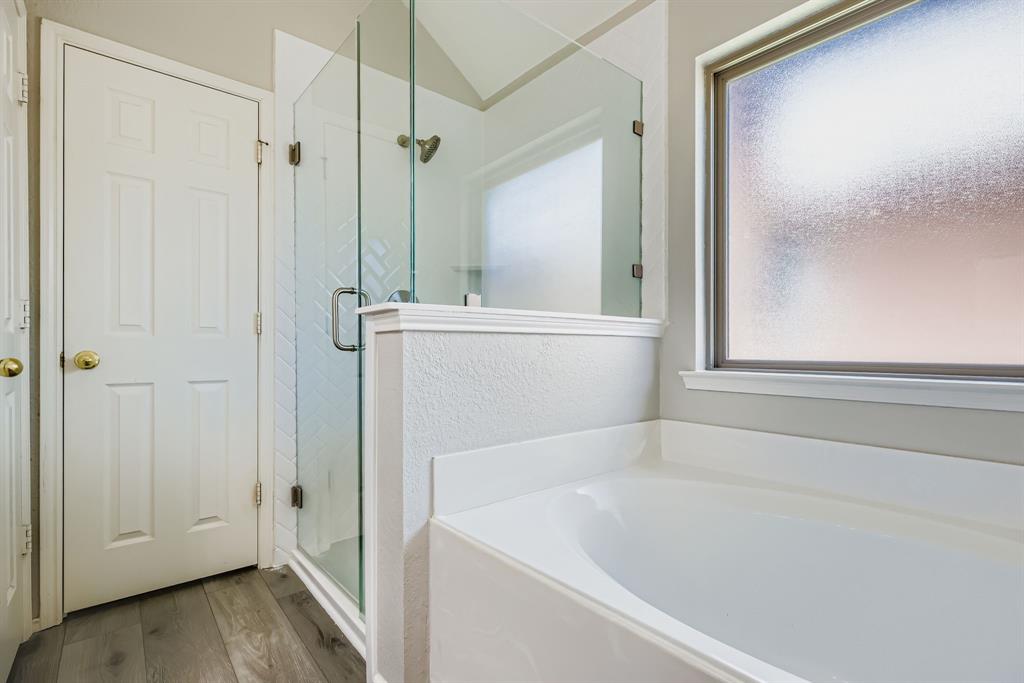 5452 Buckskin Drive The Colony, TX 75056 - Photo 23 of 31 Full bathroom featuring a soaking tub, separate shower stall, and wood finished floors