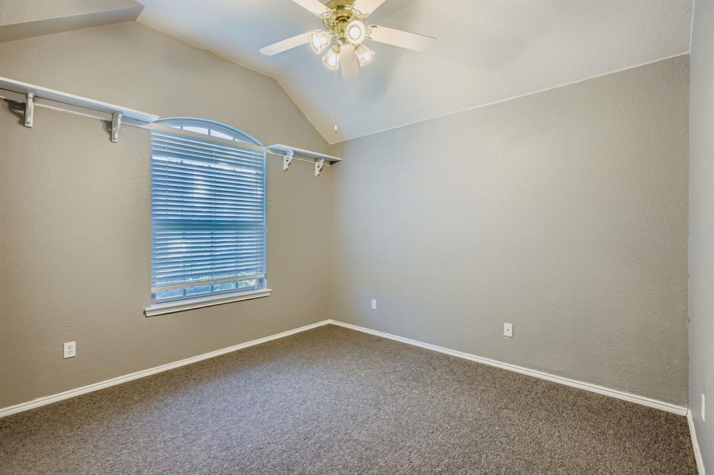 5452 Buckskin Drive The Colony, TX 75056 - Photo 24 of 31 Carpeted secondary bedrooom with a textured wall, vaulted ceiling, and a ceiling fan
