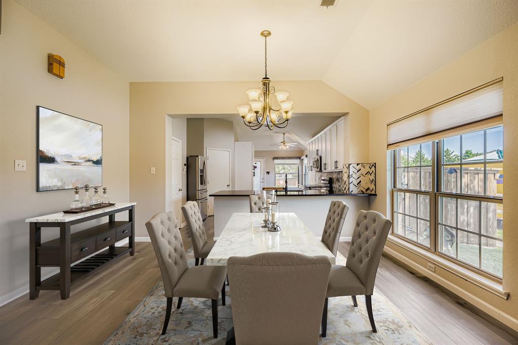5452 Buckskin Drive The Colony, TX 75056 - Photo 6 of 31 Dining space with light wood-type flooring, a chandelier, and vaulted ceiling