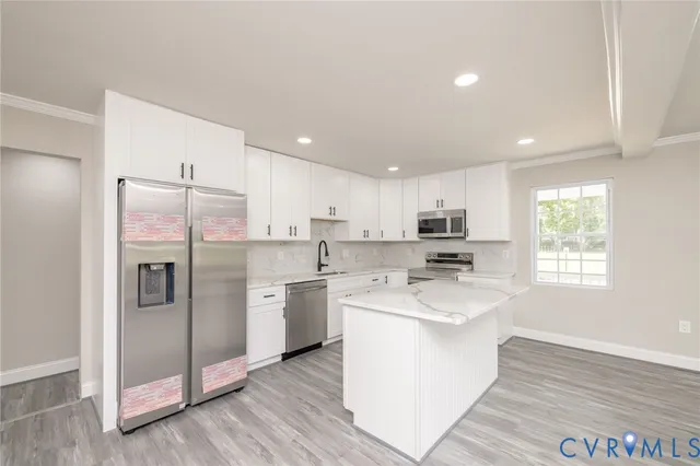 a kitchen with stainless steel appliances granite countertop a refrigerator a oven a sink a stove and white cabinets with wooden floor