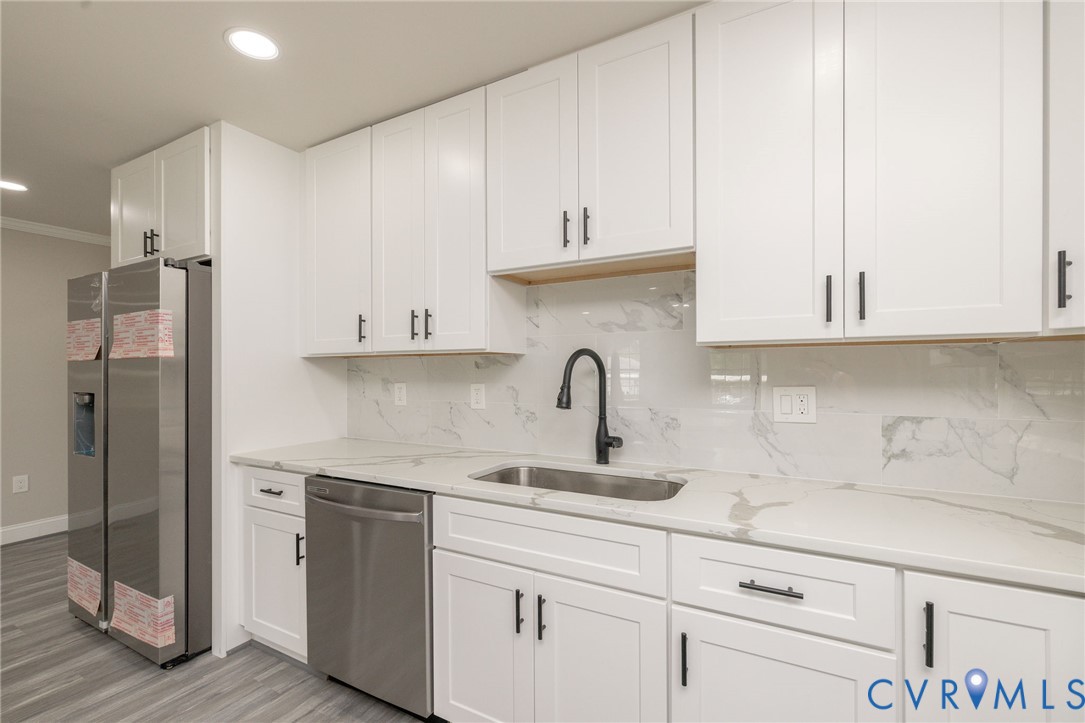 1103 Burnside Street Hopewell, VA 23860 - Photo 17 of 44 a kitchen with stainless steel appliances granite countertop a sink a stove and a refrigerator with wooden cabinets