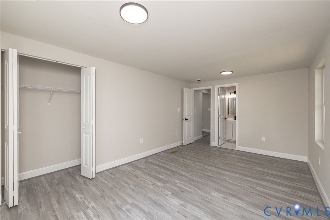 1103 Burnside Street Hopewell, VA 23860 - Photo 21 of 44 an empty room with wooden floor and windows