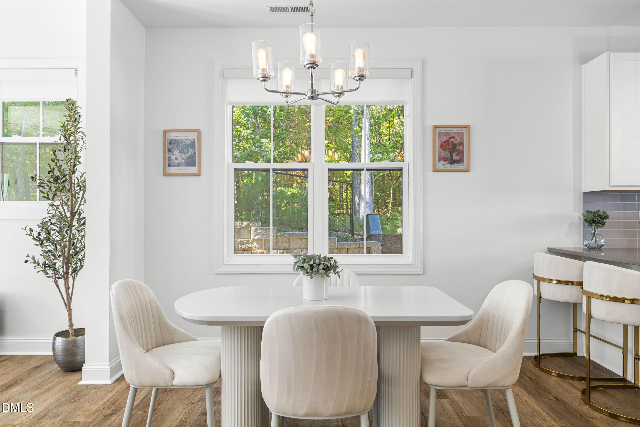 5631 Johnson Woods Court Raleigh, NC 27609 - Photo 9 of 34 a dining room with furniture a large window and wooden floor