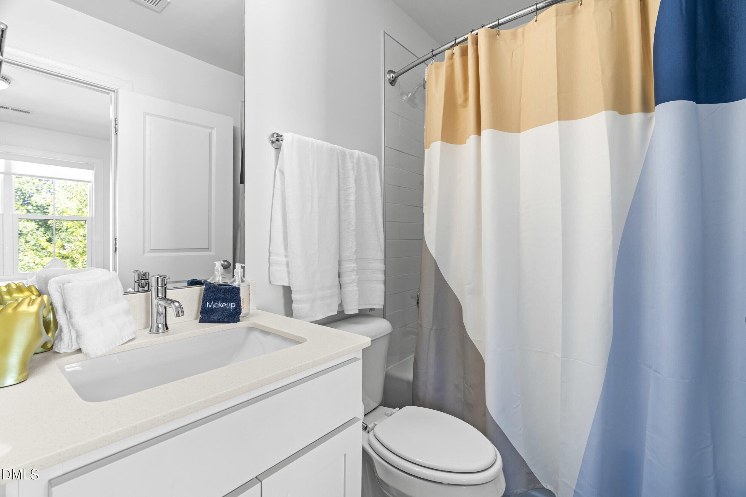 5631 Johnson Woods Court Raleigh, NC 27609 - Photo 21 of 34 a bathroom with a sink a toilet and shower curtain