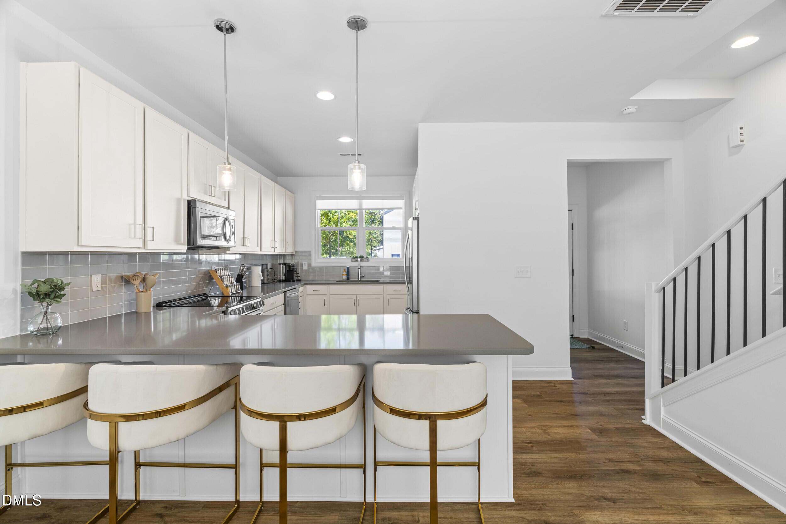5631 Johnson Woods Court Raleigh, NC 27609 - Photo 5 of 34 a kitchen with a table chairs and white cabinets