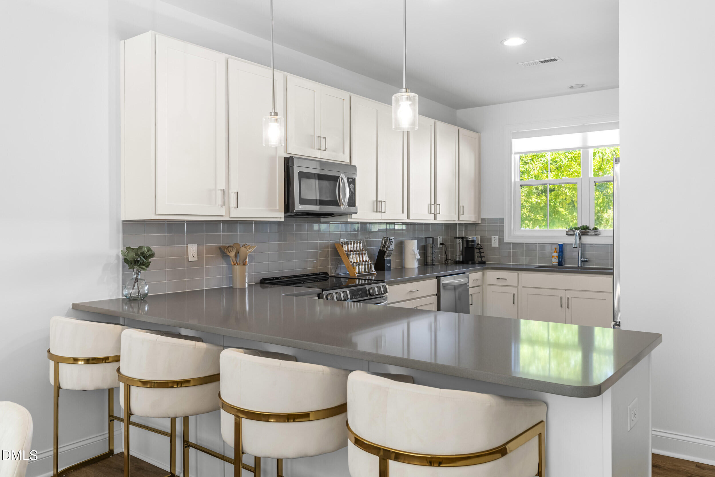 5631 Johnson Woods Court Raleigh, NC 27609 - Photo 6 of 34 a kitchen with kitchen island granite countertop a white cabinets and chairs
