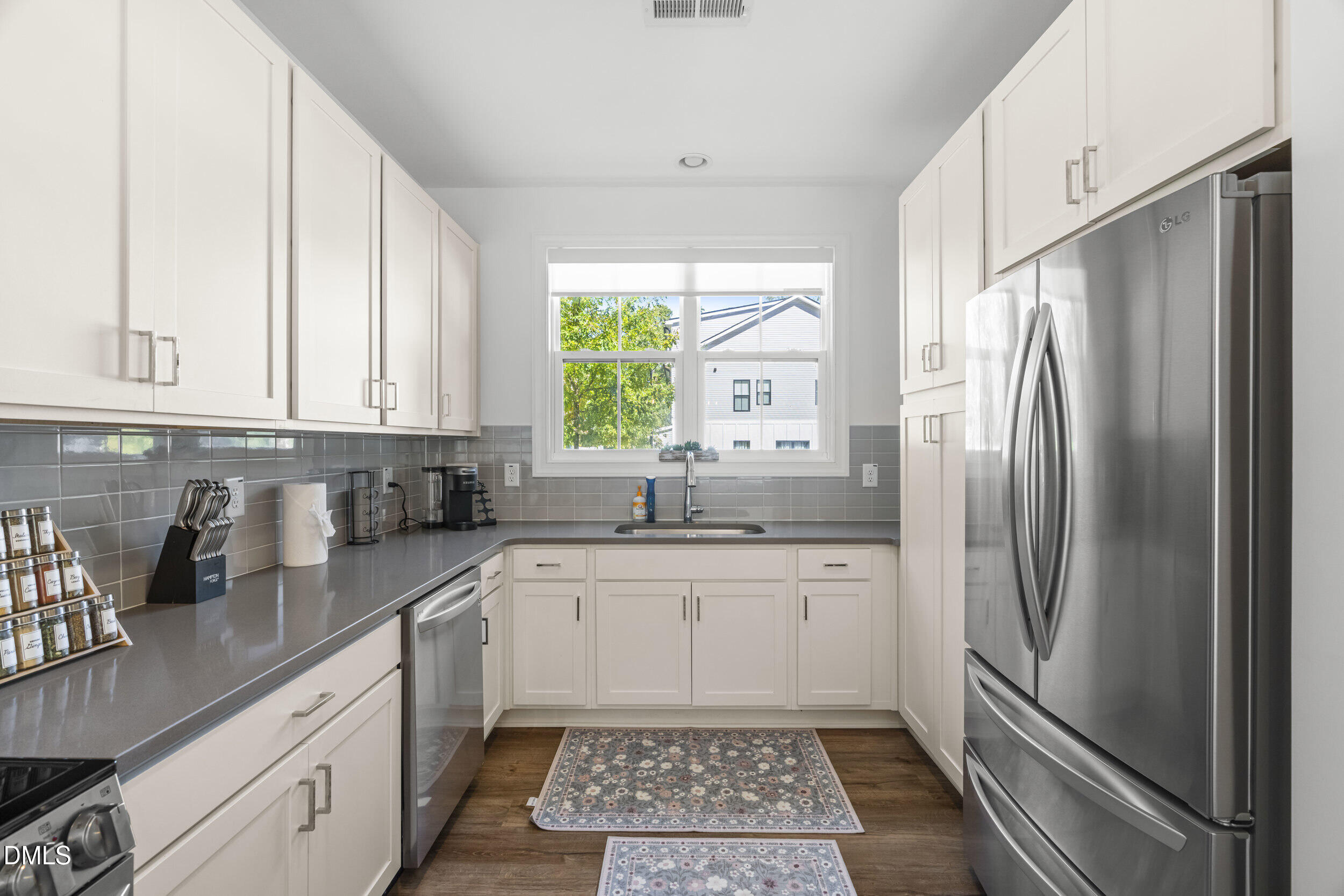 5631 Johnson Woods Court Raleigh, NC 27609 - Photo 7 of 34 a kitchen with granite countertop a sink stainless steel appliances and cabinets