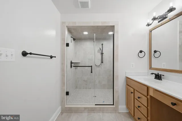 a bathroom with a shower sink and mirror