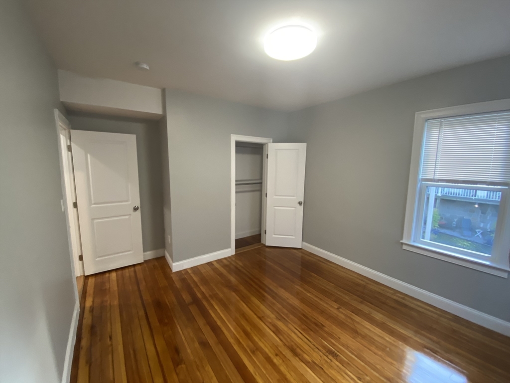 27 Juliette Street Boston, MA 02122 - Photo 11 of 37 a view of an empty room with wooden floor and a window