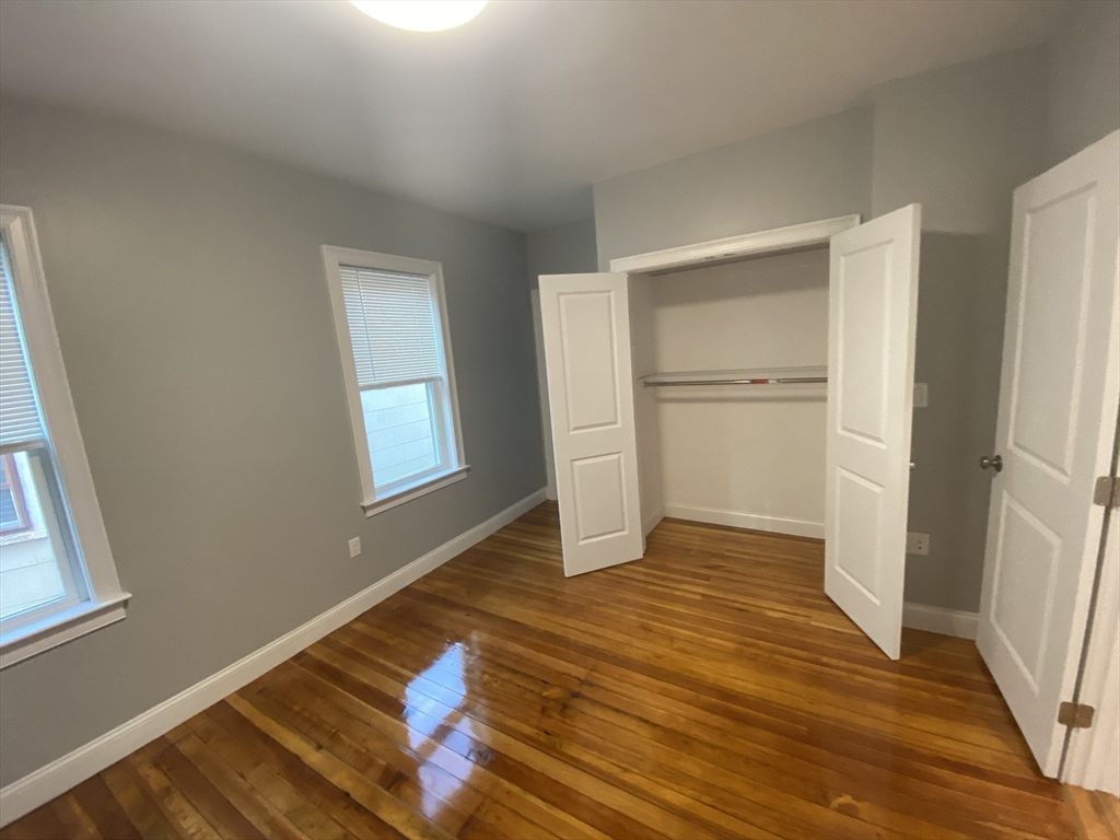 27 Juliette Street Boston, MA 02122 - Photo 14 of 37 a view of an empty room with wooden floor and a window