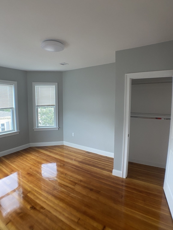 27 Juliette Street Boston, MA 02122 - Photo 25 of 37 an empty room with wooden floor and windows