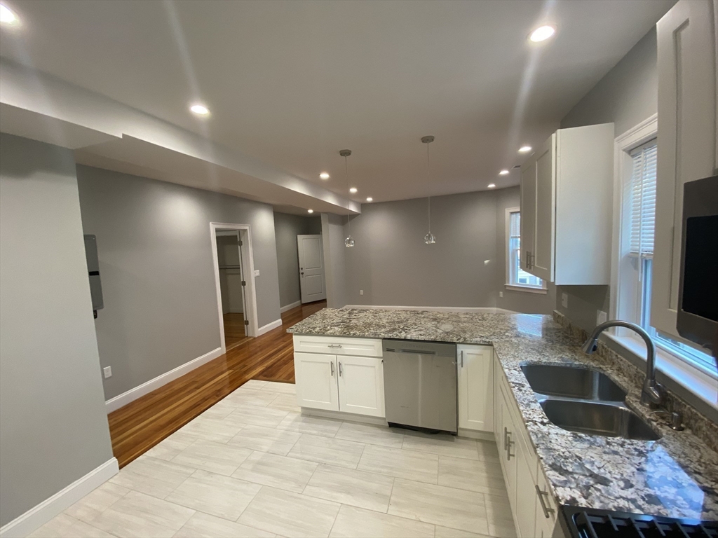27 Juliette Street Boston, MA 02122 - Photo 7 of 37 a kitchen with stainless steel appliances granite countertop a sink and a refrigerator