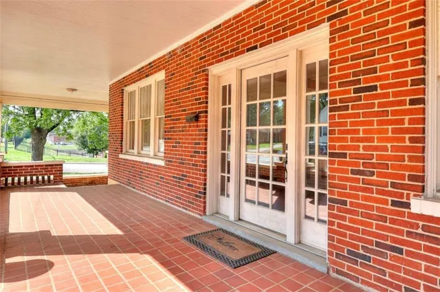 a view of a livingroom with a fireplace wooden floor and windows