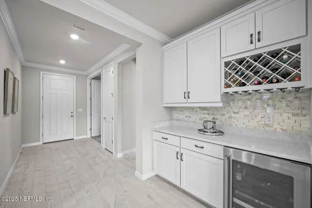 a large white kitchen with a large window a sink and stainless steel appliances
