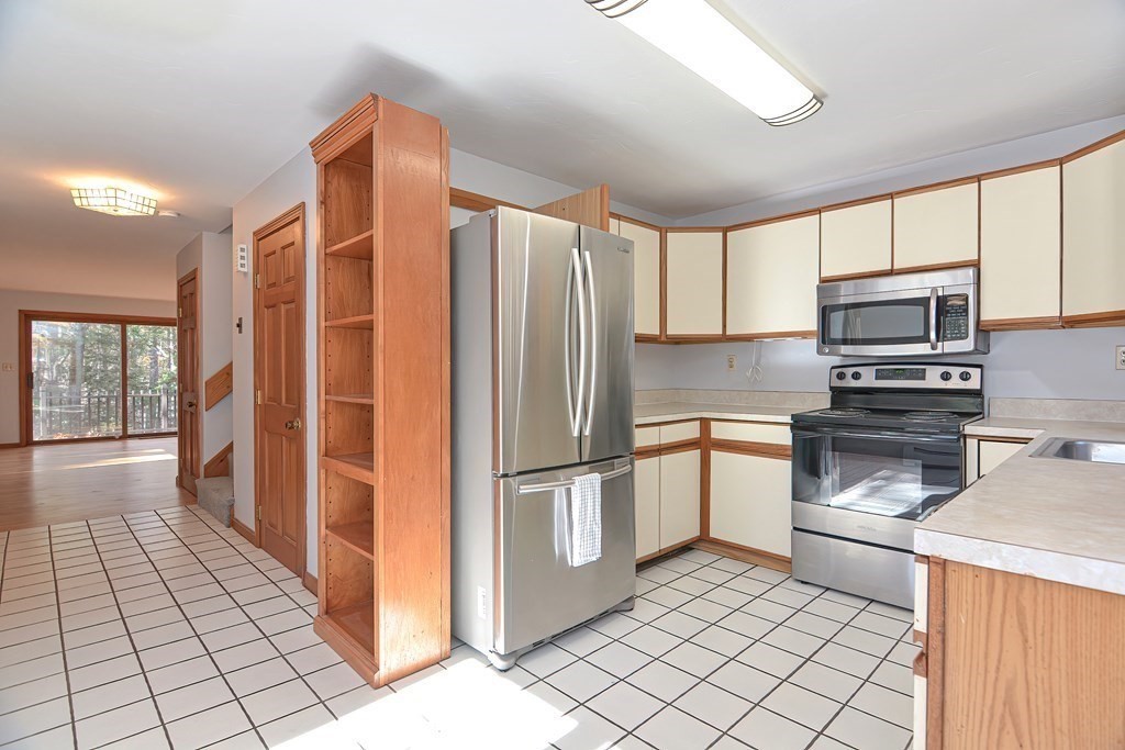 88 Townsend Road, Unit A Shirley, MA 01464 - Photo 7 of 35 a kitchen with stainless steel appliances granite countertop a refrigerator and a stove top oven