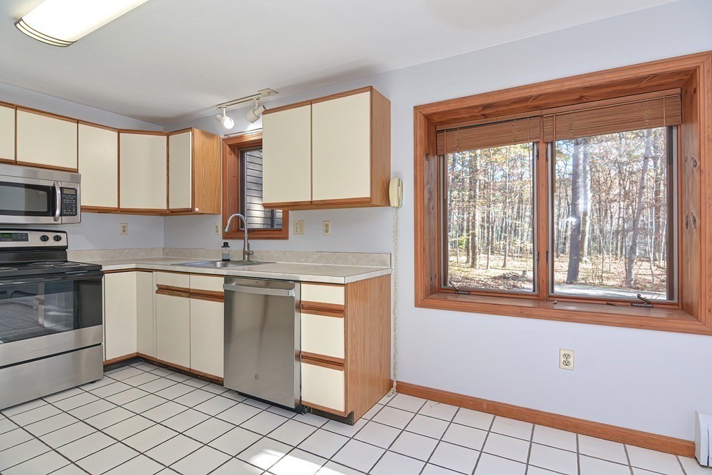 88 Townsend Road, Unit A Shirley, MA 01464 - Photo 8 of 35 a kitchen with a stove a sink and a microwave