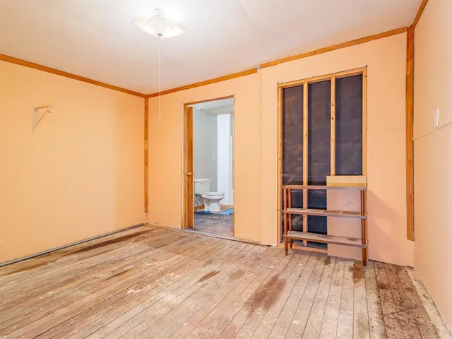 an empty room with wooden floor and closet