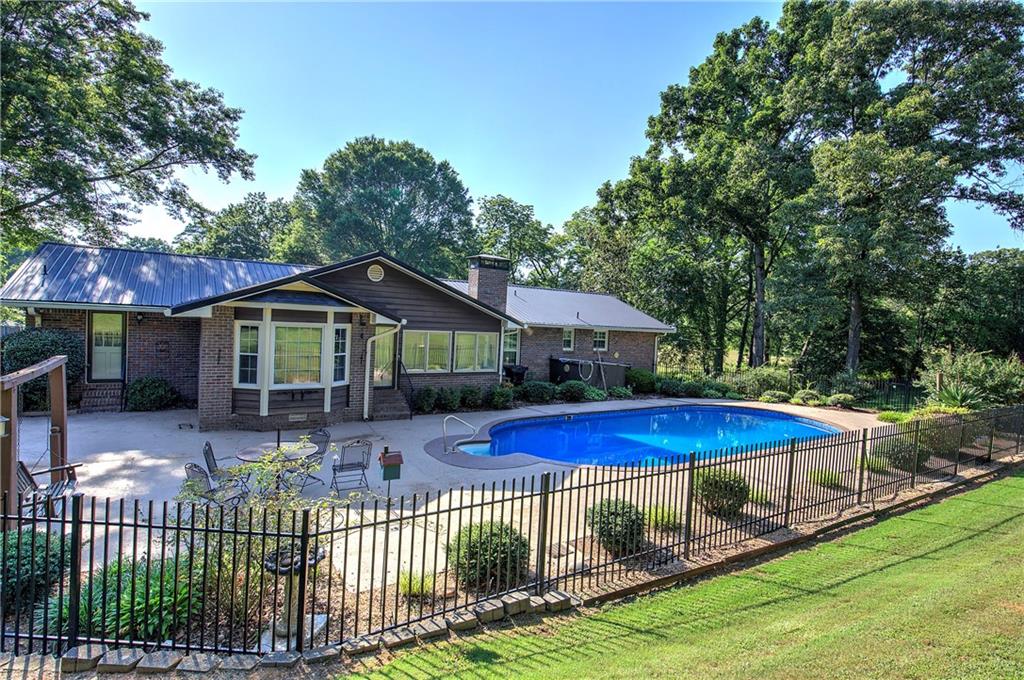 408 Mac Johnson Road Northwest Cartersville, GA 30121 - Photo 61 of 79 a front view of a house with a yard table and chairs