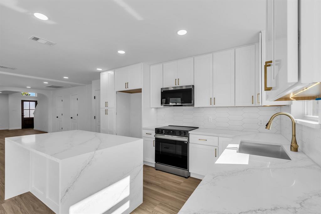 906 Thistle Circle Allen, TX 75002 - Photo 14 of 40 a large white kitchen with stainless steel appliances granite countertop a stove a sink a refrigerator and a cabinets