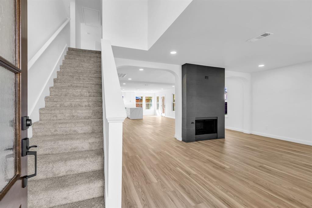 906 Thistle Circle Allen, TX 75002 - Photo 4 of 40 a view of a hallway with wooden floor and staircase