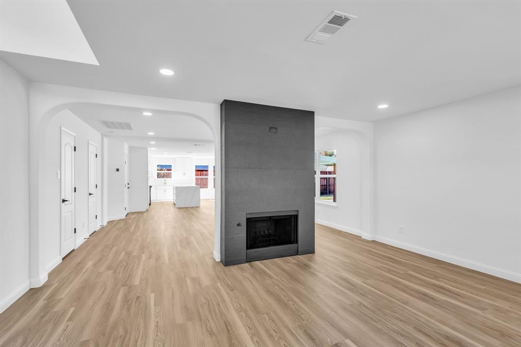 906 Thistle Circle Allen, TX 75002 - Photo 6 of 40 a view of a hallway with wooden floor and a fireplace