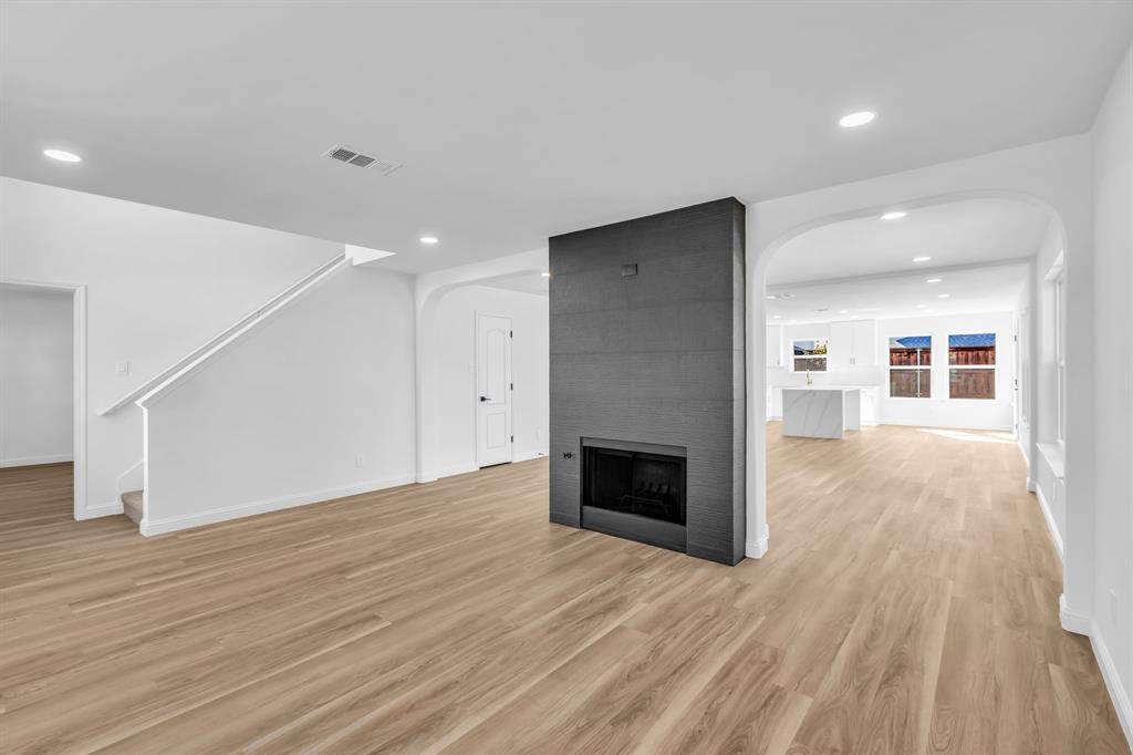 906 Thistle Circle Allen, TX 75002 - Photo 7 of 40 a view of empty room with wooden floor and fireplace