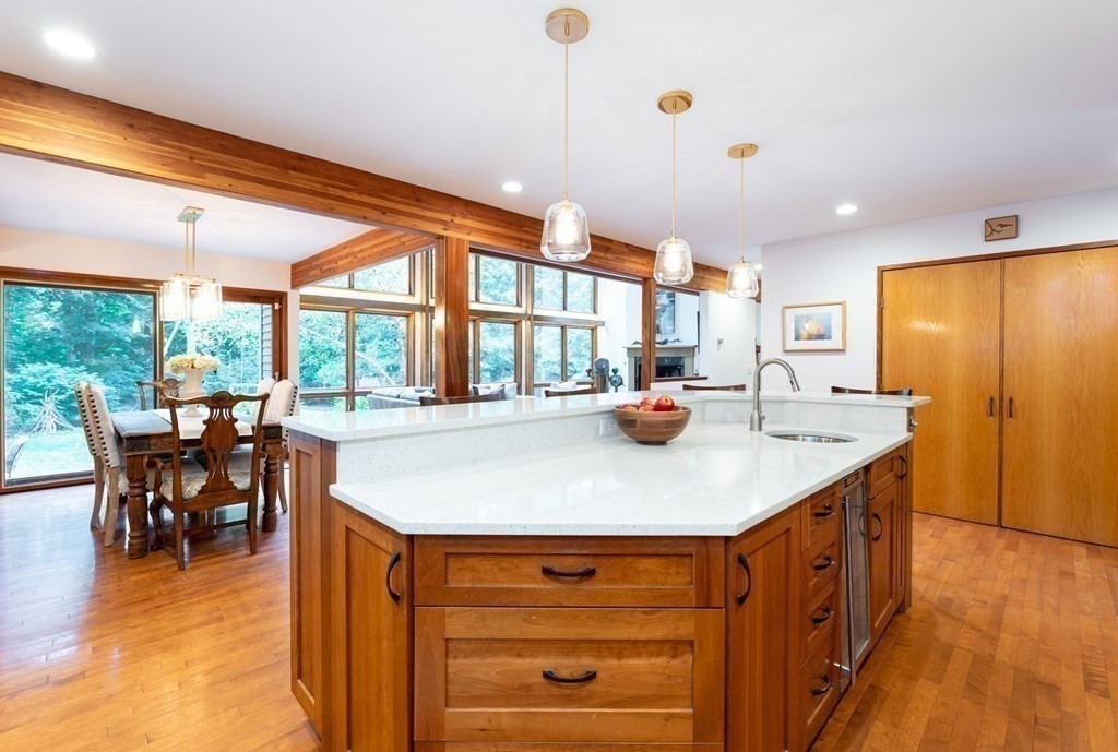 12 Rice Spring Lane Wayland, MA 01778 - Photo 11 of 37 a kitchen with stainless steel appliances kitchen island granite countertop a table chairs and a refrigerator