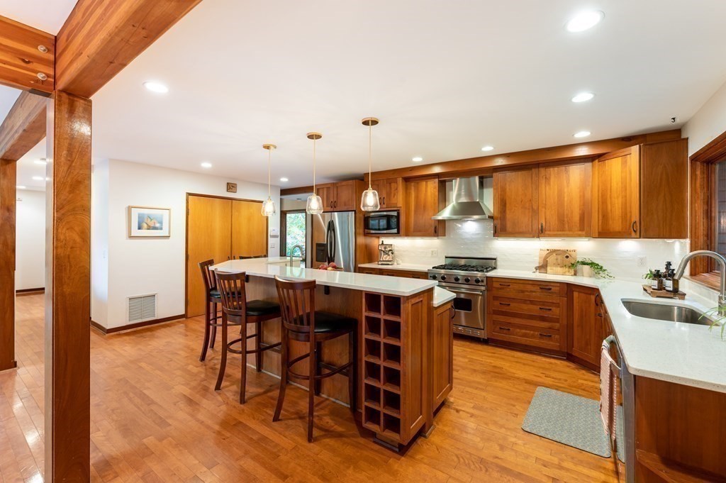 12 Rice Spring Lane Wayland, MA 01778 - Photo 13 of 37 a kitchen with stainless steel appliances granite countertop a table chairs sink and cabinets
