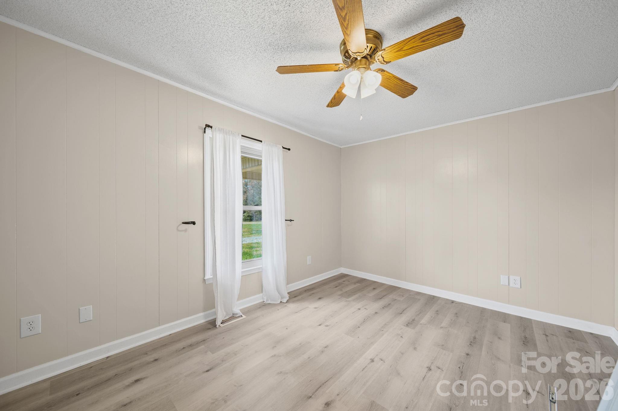 235 Spring Estates Circle Salisbury, NC 28146 - Photo 23 of 47 an empty room with wooden floor and a ceiling fan