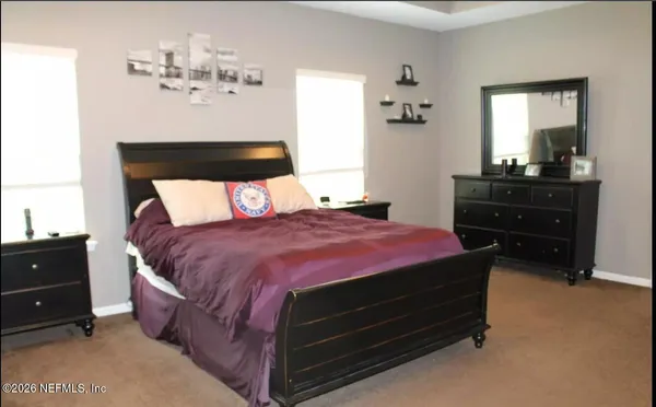 a bed sitting in a bedroom and dresser