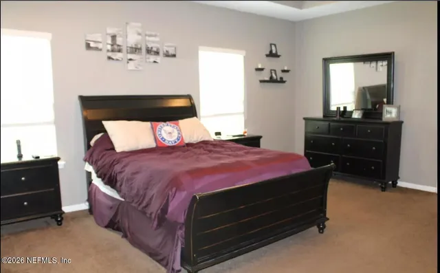 a bed sitting in a bedroom and dresser