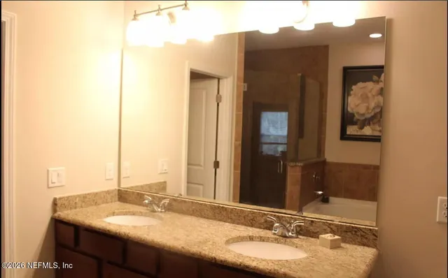 a bathroom with a granite countertop sink and a mirror