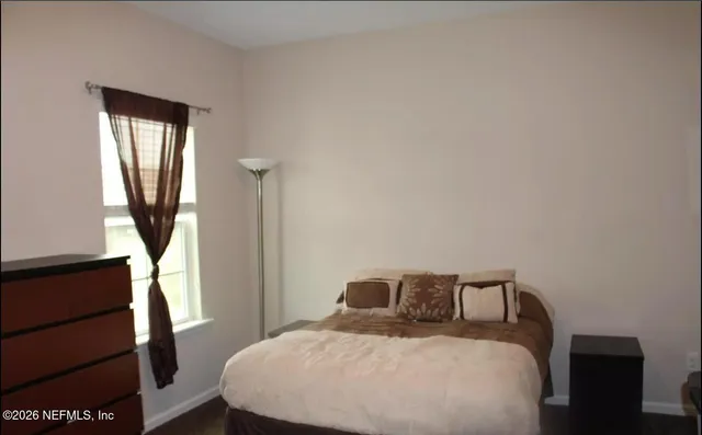 a bedroom with a bed a mirror and a window