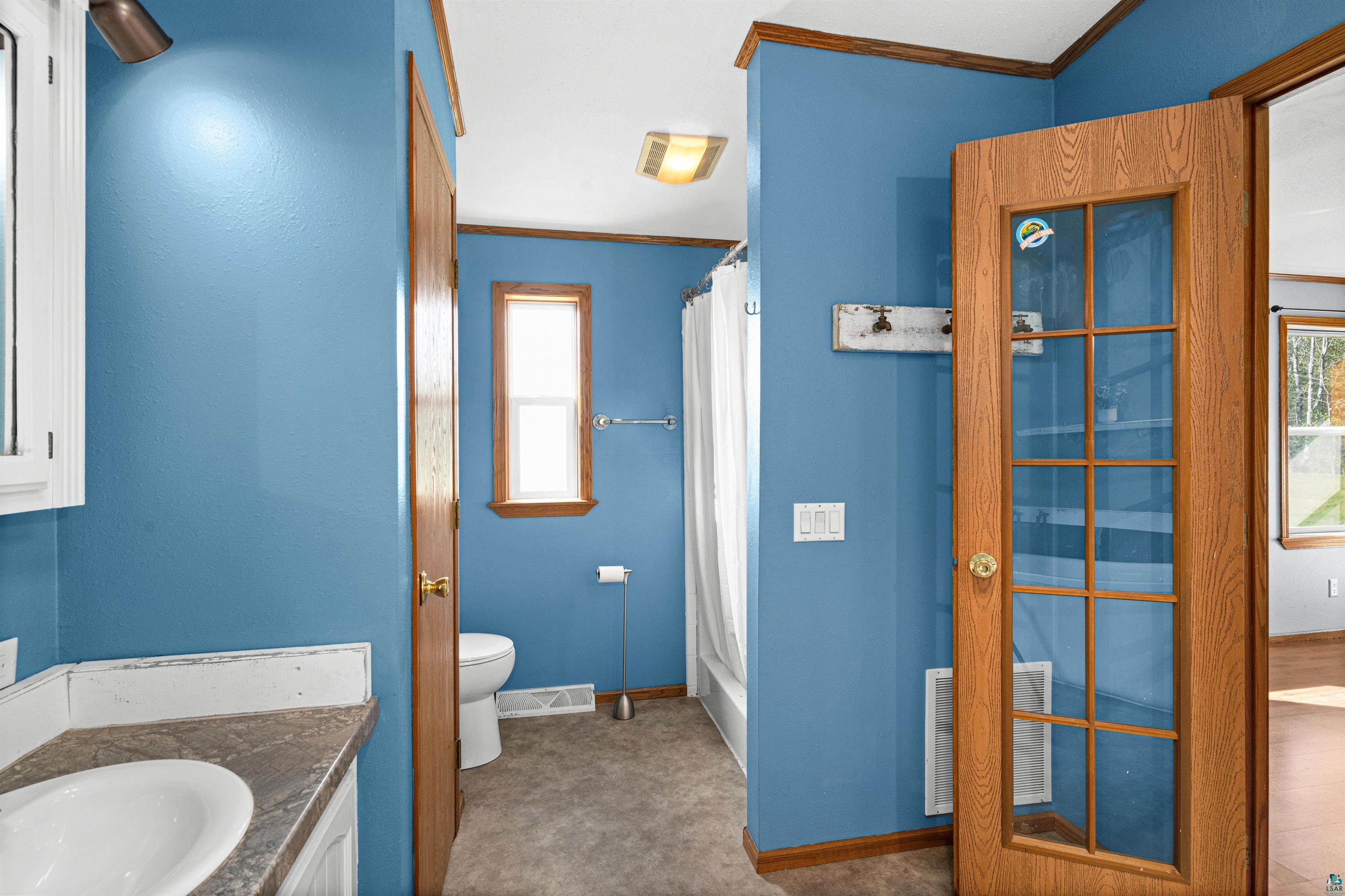 3126 Beyer Road Duluth, MN 55804 - Photo 19 of 23 Bathroom featuring a white vanity with a built-in sink, a window, a full-size bathtub with shower, and a glass-paneled interior door