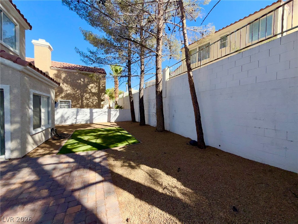 9729 Trail Rider Drive Las Vegas, NV 89117 - Photo 24 of 26 A private outdoor space with a paver patio and low-maintenance landscaping for relaxation.