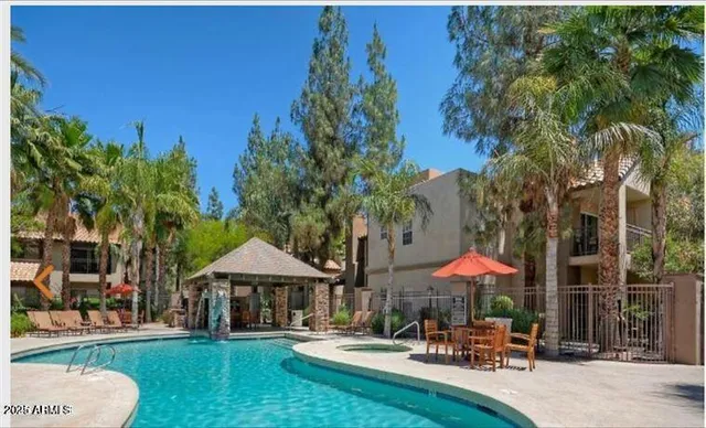 a patio with a table and chairs under an umbrella