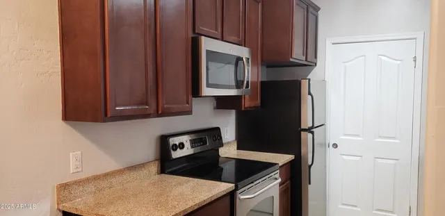 a kitchen with a refrigerator stove and cabinets
