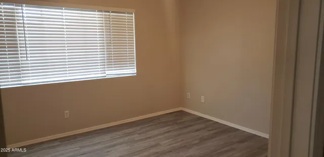 an empty room with wooden floor and a window
