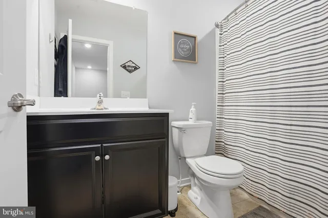 a bathroom with a toilet a sink and mirror