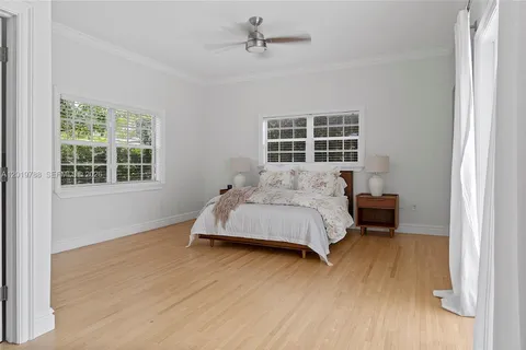 a spacious bedroom with a bed and wooden floor