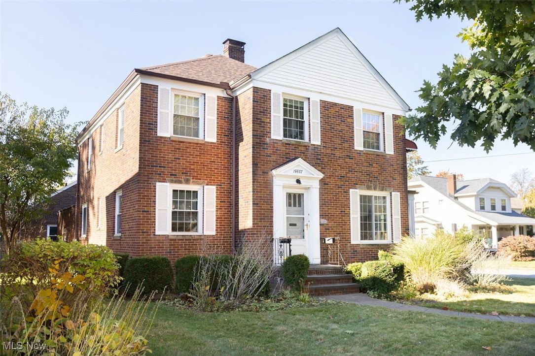 15537 Munn Road Cleveland, OH 44111 - Photo 2 of 38 View of front of home with a chimney, a front yard, and brick siding