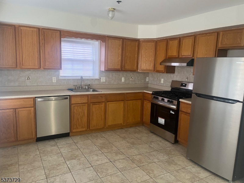 98 Quitman Street Newark, NJ 07102 - Photo 5 of 15 a kitchen with a sink a stove and refrigerator