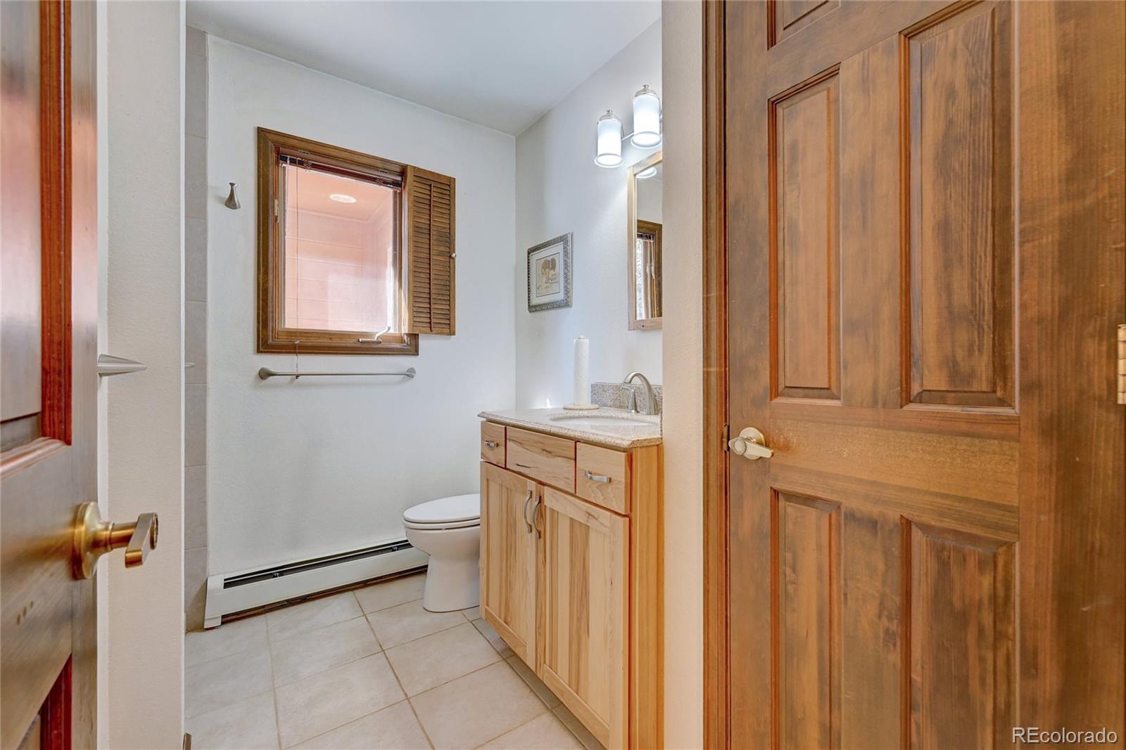 411 Spring Drive Pine, CO 80470 - Photo 13 of 40 a bathroom with a sink a toilet and shower curtain