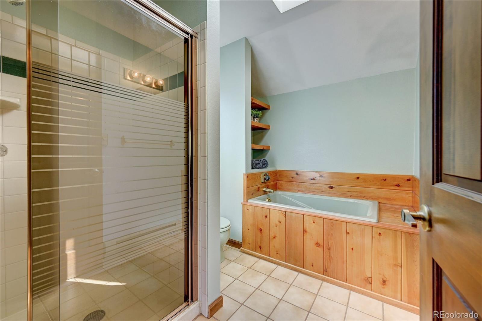 411 Spring Drive Pine, CO 80470 - Photo 24 of 40 a bathroom with a tub and a shower