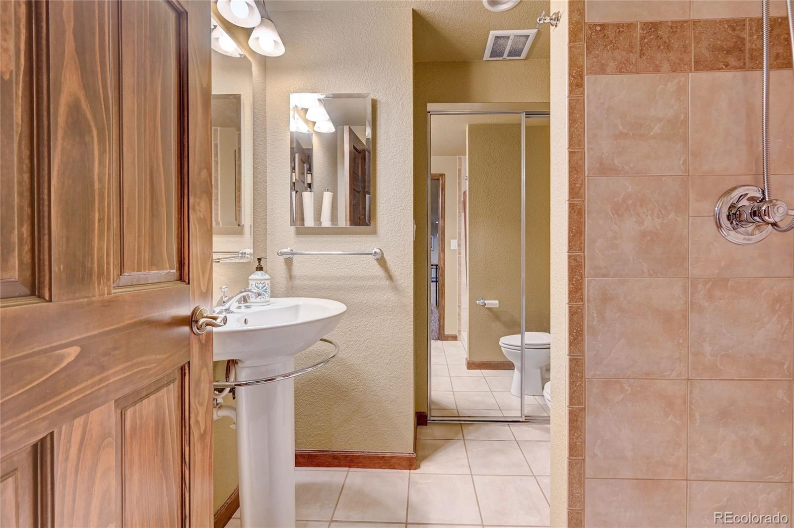 411 Spring Drive Pine, CO 80470 - Photo 26 of 40 a bathroom with a sink a toilet and shower